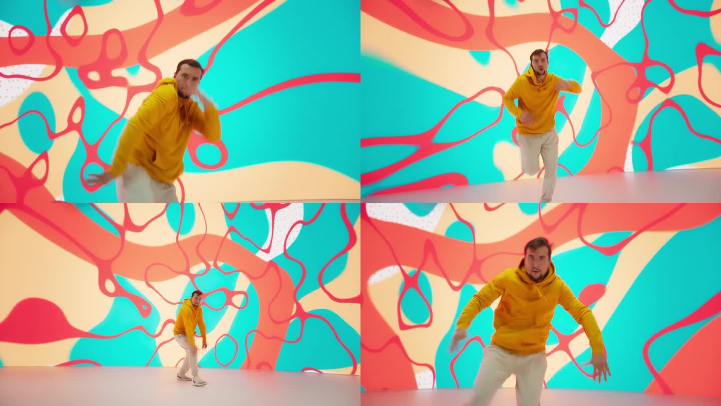 动感男舞者在明亮的毛衣表演快速霹雳舞动作在一个色彩缤纷的工作室。专业的B-Boy展示他的才华和技能，