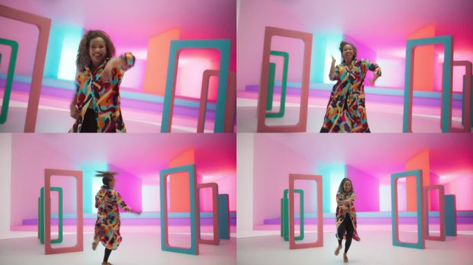 彩色几何抽象美学:黑人妇女在工作室里随着充满活力的音乐快乐地跳舞的肖像。活泼的女舞者庆祝生命，用动作