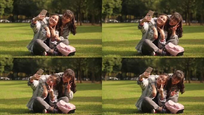 开心闺蜜在大学校园草坪用手机自拍美女可爱