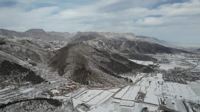 山脚下被大雪覆盖的农田