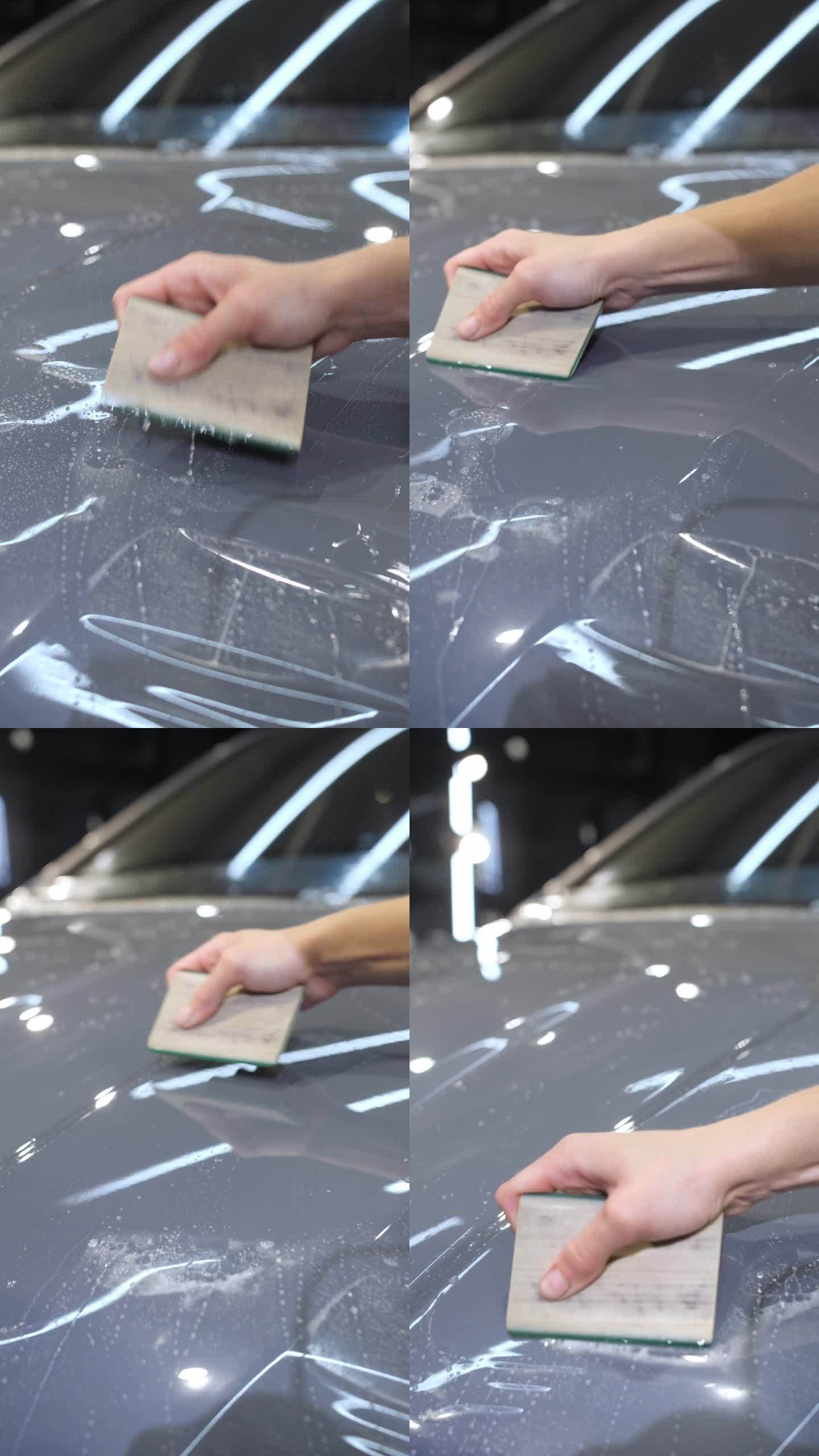 一只手拿着塑料刮板在新车上涂上了一层防砾石保护膜