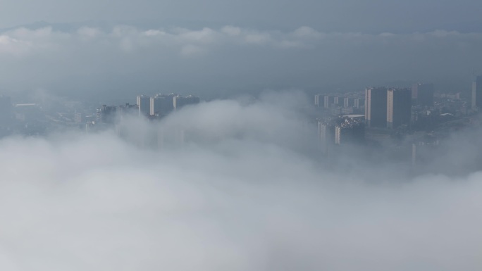 航拍视觉上升到流云面云下城市高楼