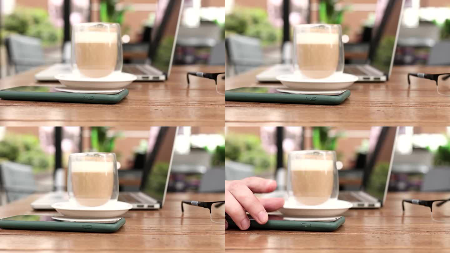 现代锁着的智能手机躺在咖啡桌上，男性的手拿起它。