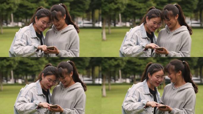 两位女大学生在校园看手机网购学习开心交谈
