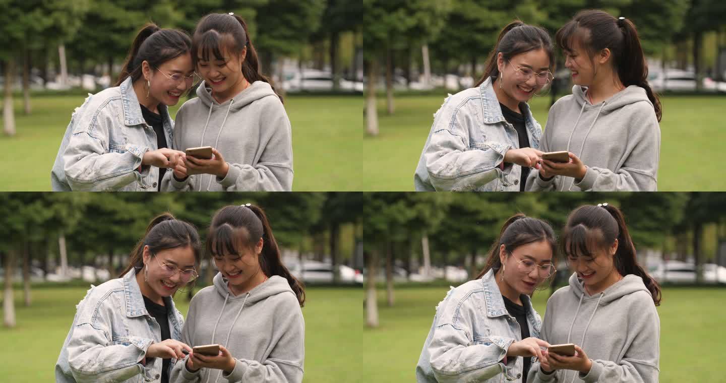 两位女大学生在一起聊天看手机网购学习