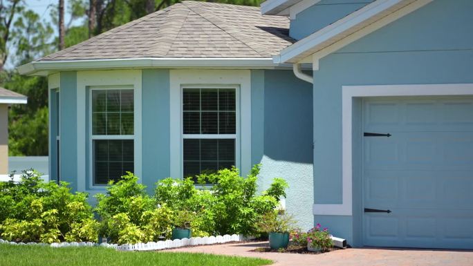 佛罗里达州南部普通私人住宅的正面视图。单户住宅，双车库门和宽车道