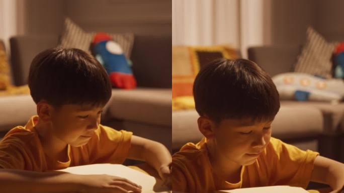竖屏:一个韩国小男孩晚上在客厅的笔记本上思考和书写的肖像。创意男孩运用想象力，写故事，梦想成为作家