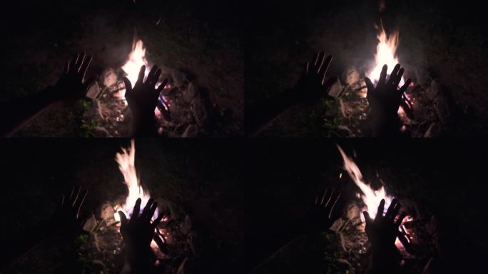 无法辨认的手在营火上暖和起来
