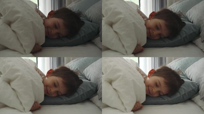 微笑的男孩在床上醒来，窗帘打开，阳光照进来。