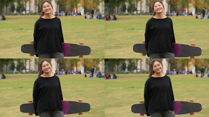 女大学生拿着长板滑板看镜头微笑
