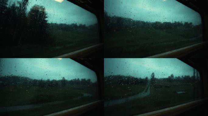 大雨中透过火车窗户看到的壮观景色。雨滴顺着窗玻璃流下来。行驶中的火车窗外下着大雨。在雨中乘火车去山里
