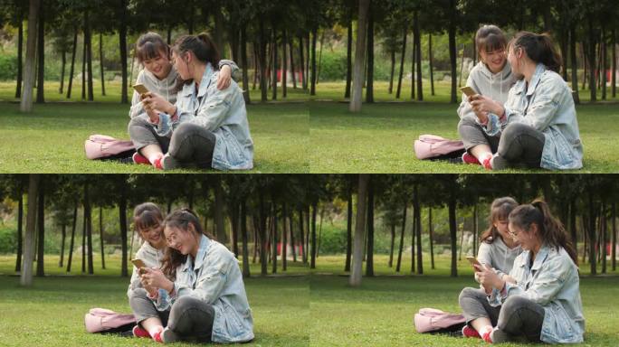 两位女大学生坐在校园草地上看手机学习交谈