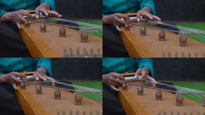 年长的成年人戴着布兰康(一种西爪哇的传统帽子)，穿着传统服装，弹着竖琴或古筝