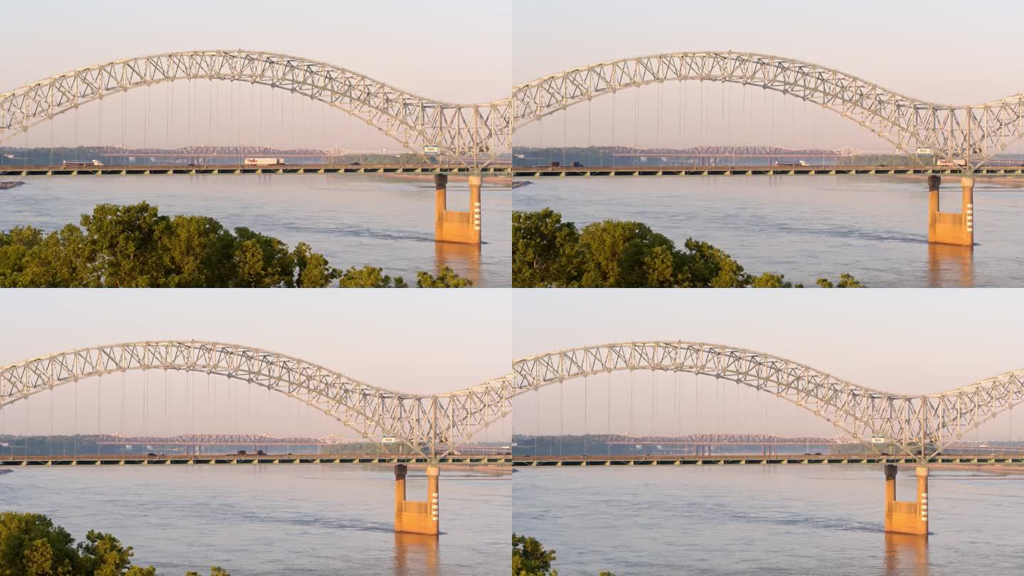 日落时分，田纳西州孟菲斯的埃尔南多·德索托大桥上的交通。平铺拱桥横跨密西西比河，映衬着壮观的天空。航
