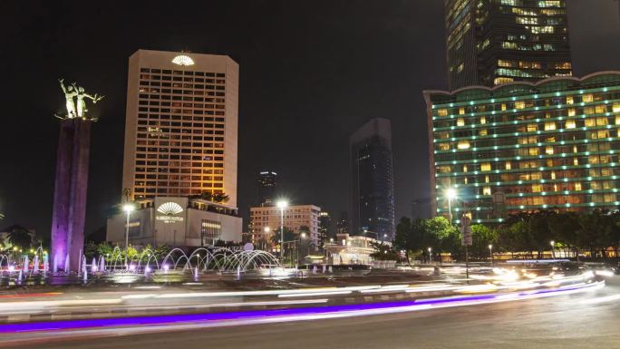 夜间照明雅加达市中心著名的圆圈交通广场喷泉纪念碑全景4k延时印度尼西亚