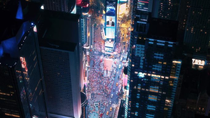直升机夜游纽约市。飞越发光的时代广场和五颜六色的模拟广告牌和成群的游客享受曼哈顿的夜生活和欣赏地标