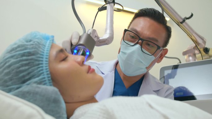 皮肤科医生在美容诊所用激光治疗面部皮肤问题。