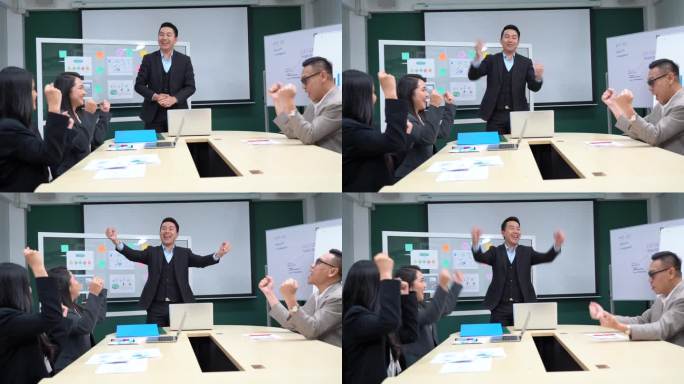 在会议室里，快乐的亚洲商人经理或领导老板在演讲中激励同事加油鼓劲，向胜利者举起拳头