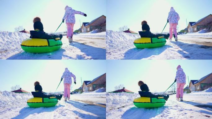 快乐的孩子们在寒假里玩冬季滑冰圈。两个孩子在雪地里玩耍。健康的生活方式。