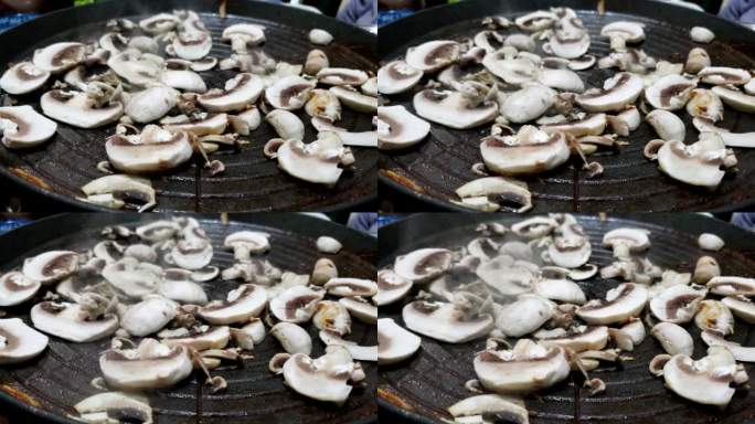 切成薄片的鲜蘑菇在热盘子上滋滋作响