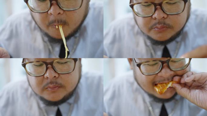 特写，一个饥肠辘辘的胖乎乎的男人在餐厅吃饭时，用叉子吃着意大利面，用手吃着炸鸡翅。