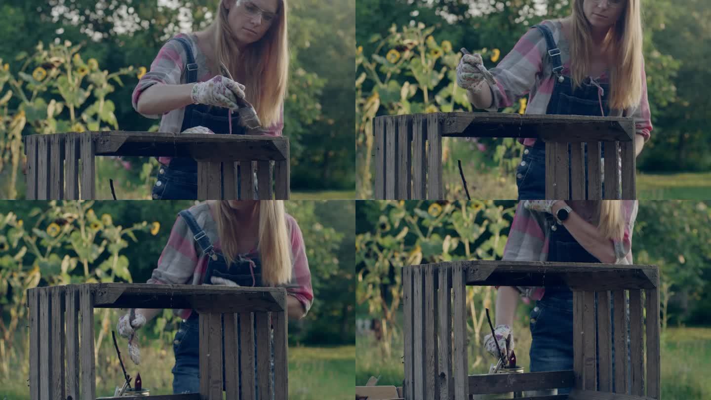 一个女人在花园里画一个木盒。DIY项目。
