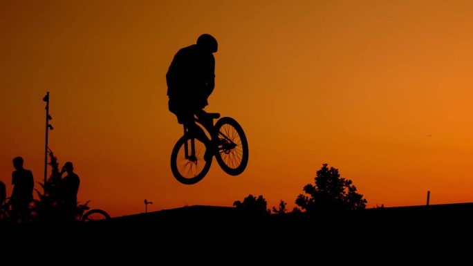 日落自行车飞跃年轻人