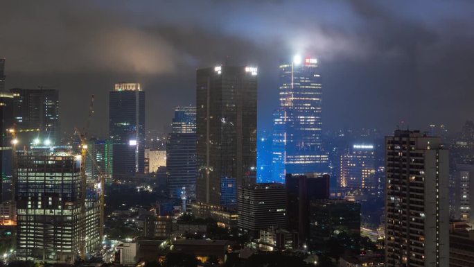 夜间照明阴雨天气雅加达市中心屋顶全景4k延时拍摄印度尼西亚