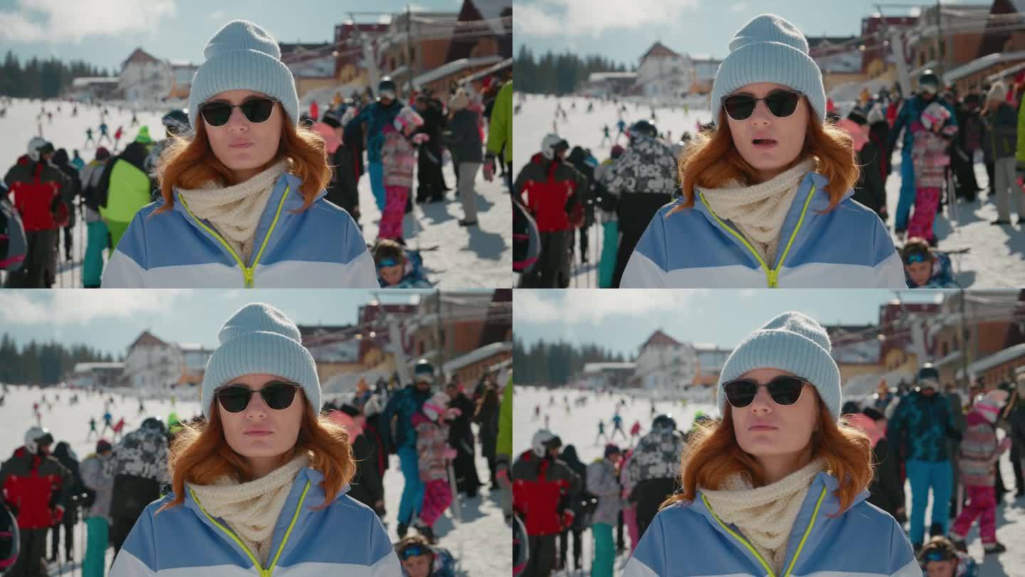 一个粗心的女人站在山上的滑雪道上嚼口香糖。