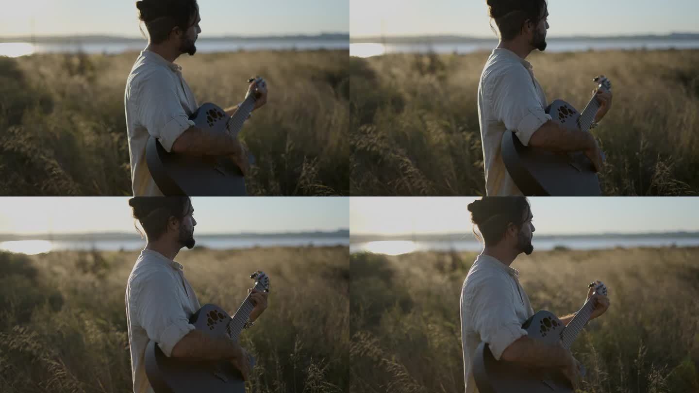 站在西班牙的草地上，在美丽的阳光下，用黑色的原声吉他演奏和弦-慢动作的侧面视图
