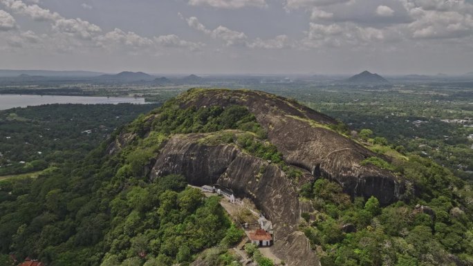 空中v5反向飞越Isigili山，拍摄皇家洞穴寺庙，山坡上的Uyanwatta寺庙和周围的村庄小镇景