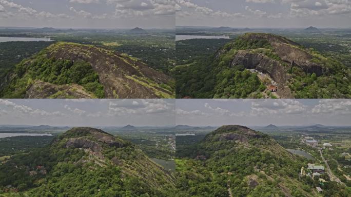 空中v5反向飞越Isigili山，拍摄皇家洞穴寺庙，山坡上的Uyanwatta寺庙和周围的村庄小镇景