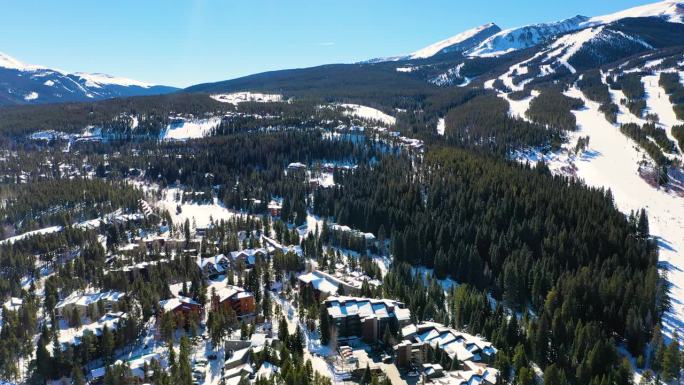落基山小镇，在寒冷的冬雪中有房子和滑雪场。无人机航拍图