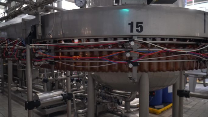 啤酒厂啤酒装瓶工艺流程。啤酒厂啤酒装瓶工艺生产线上，空铝啤酒罐正在传送带上移动