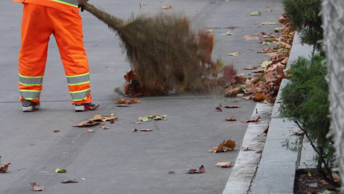 清洁工扫树叶马路