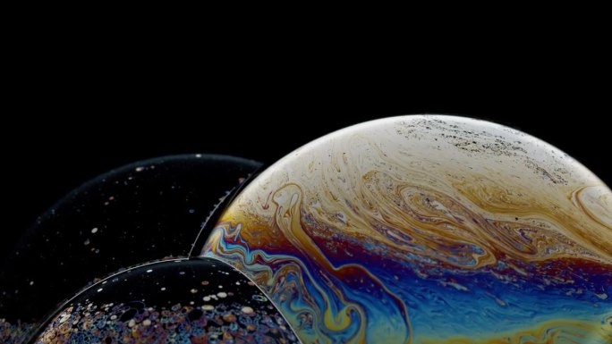 旋转的泡泡团充满了旋转的彩色油漆，就像一个行星抽象的背景
