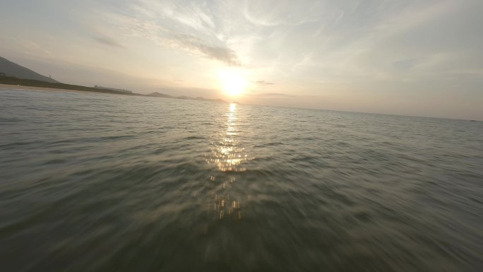 穿越机日出海边贴海飞行迎着日出希望