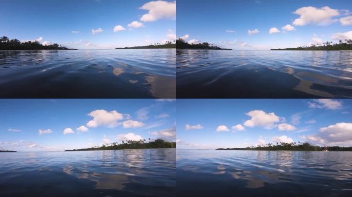 在水面上的水平窗格视图看向阿瓦纳港通道与岛屿的植被热带植物椰子树海滩边在一个美好的日子里，蓝天阳光太