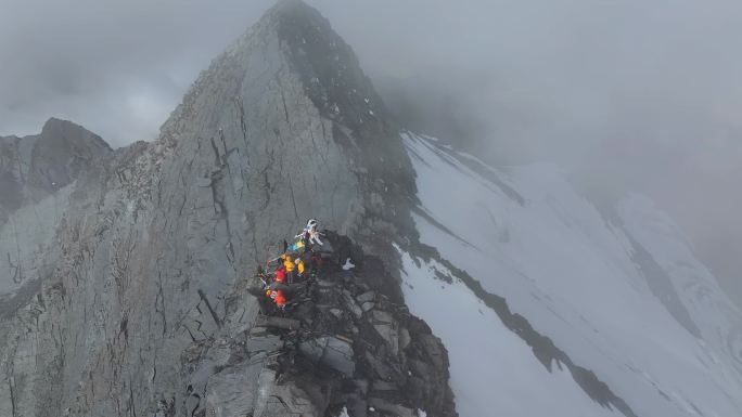 航拍登顶横断山脉乌库楚雪山的登山者