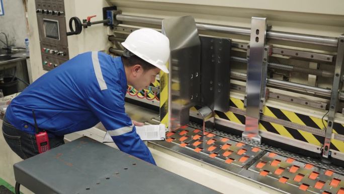 质量控制经理纸板纸厂工程师检查大型机器输送纸生产线