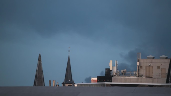 比利时安特卫普，烟雾从屋顶上吹过，光线渐渐暗淡。