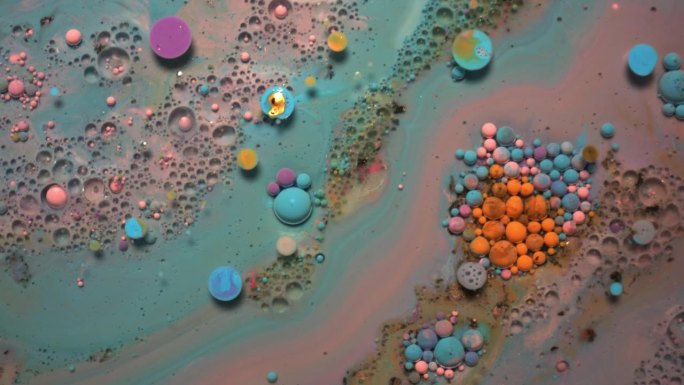 彩虹泡泡的油漆和墨水在水中。彩色液体在一起旋转