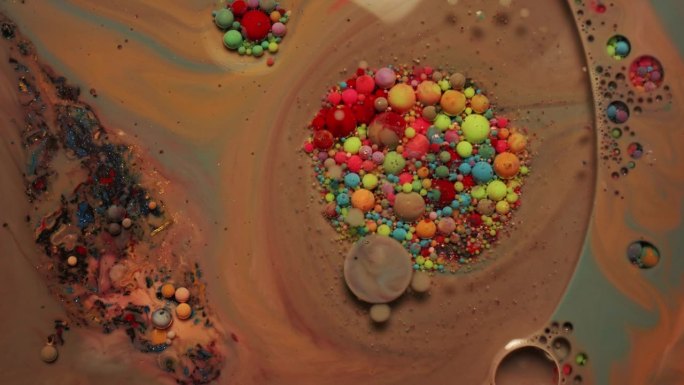 彩虹泡泡的墨水或油漆在水中。颜色旋转并混合在一起
