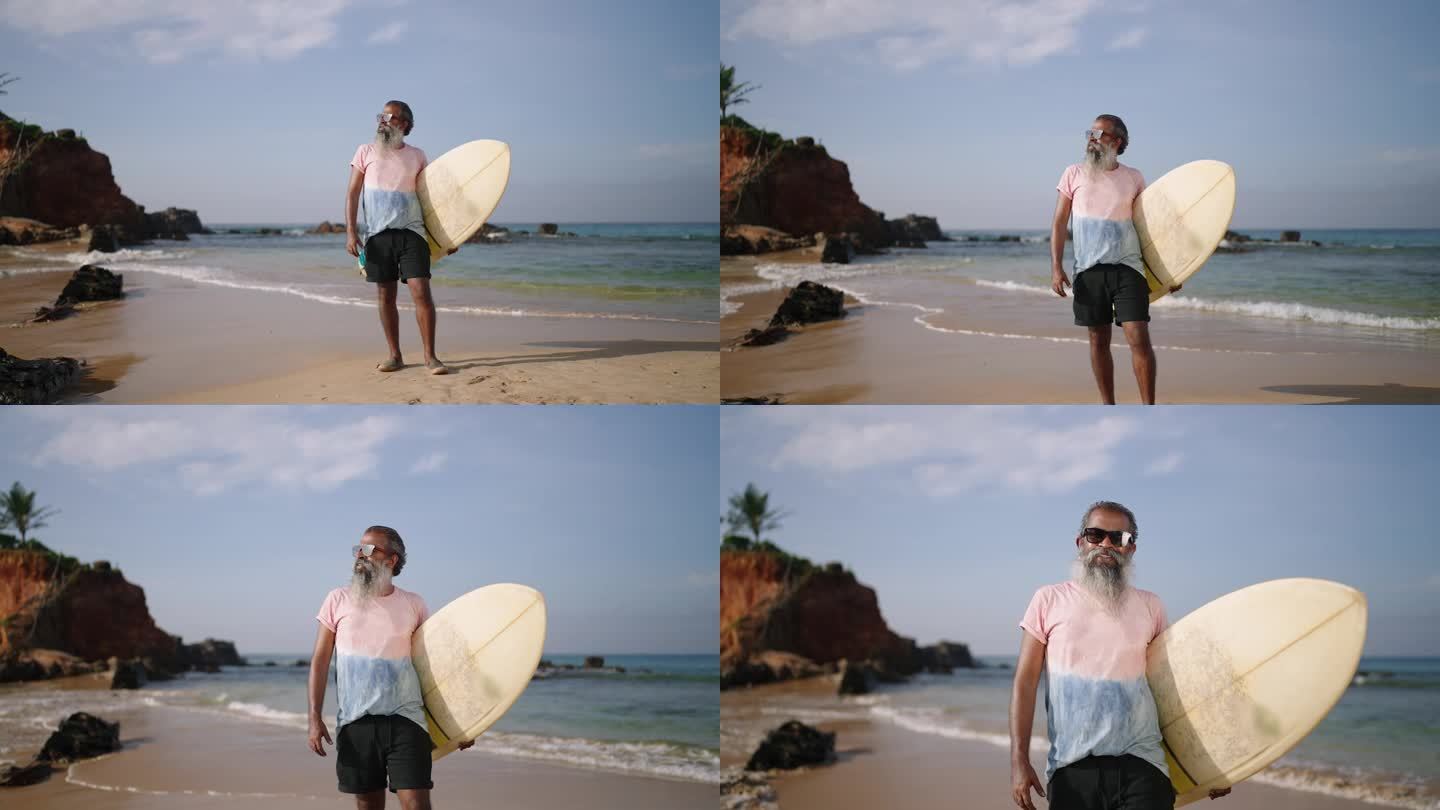 一位白发老人留下来，穿着衬衫，t恤，戴着太阳镜，在沙滩上摆着冲浪板的姿势。黑人老人微笑着面对镜头，在