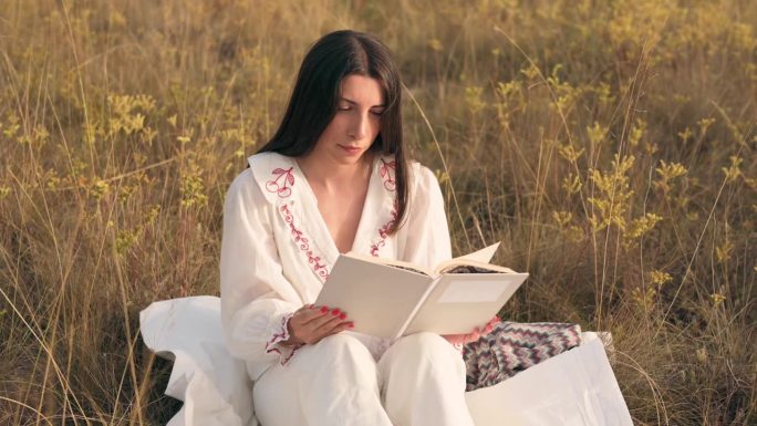 日落时分在草地上看书的女人