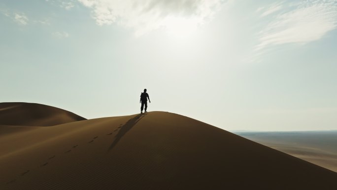 爬沙漠库木塔格沙漠上徒步的人克服困难励志