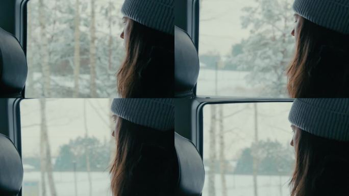 忧郁的女人坐在车里。看着窗外被雪覆盖的树木