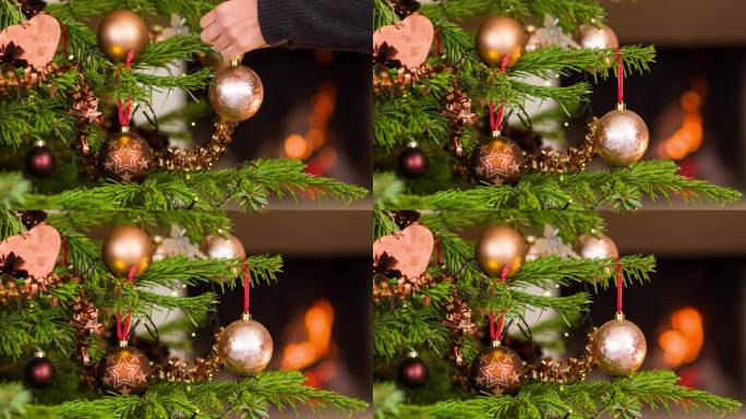 在壁炉旁用一个金色的装饰球装饰圣诞树