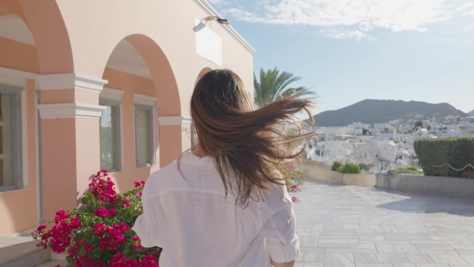 希腊圣托里尼岛伊亚的女游客。快乐的游客走在希腊著名地标圣托里尼岛的楼梯上
