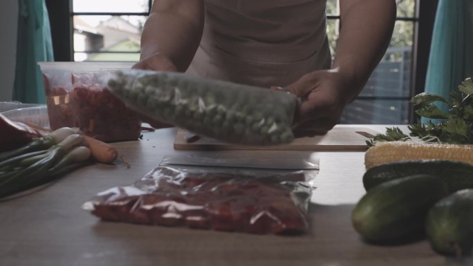 在为冬天保存食物时，用新鲜的夏季蔬菜堆叠冷冻袋